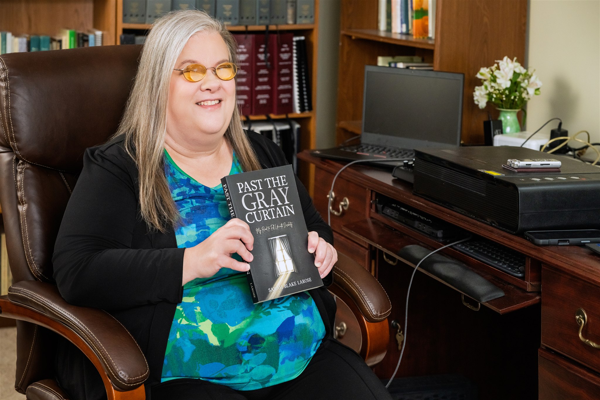 Sarah LaRose holding a book entitled Past the Gray Curtain